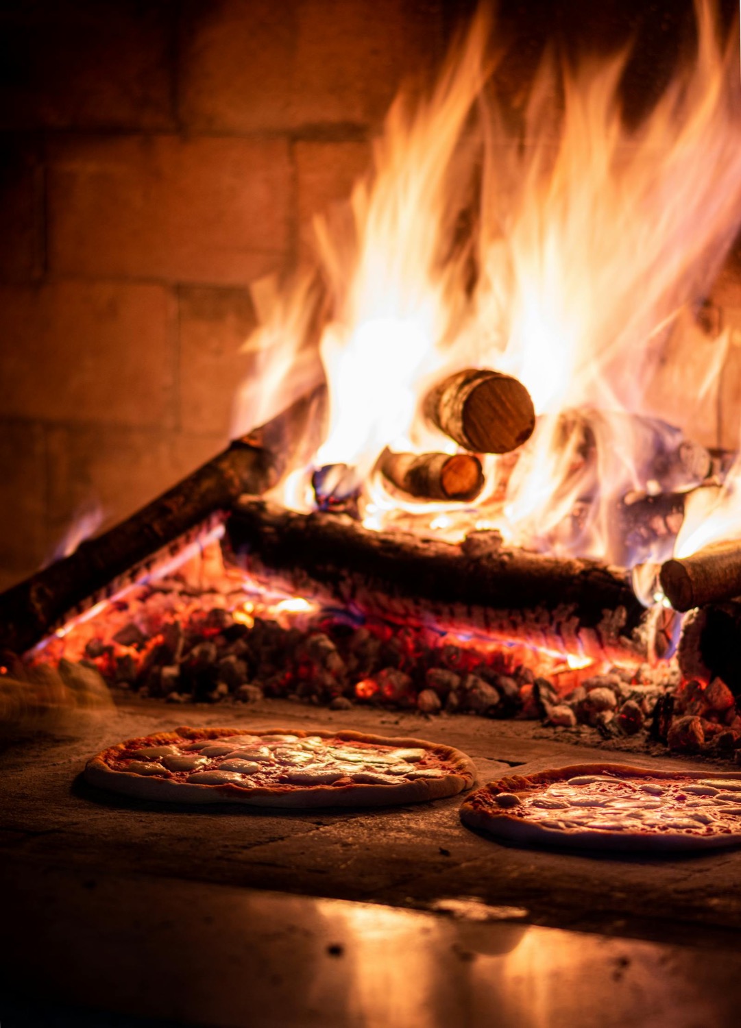 Pizzas en cuisson dans un four à bois